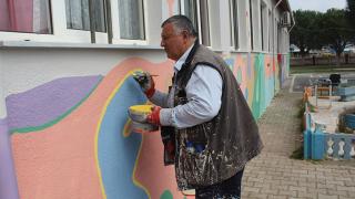 Görme engelli, gönüllü olarak okul duvarlarını renklendiriyor