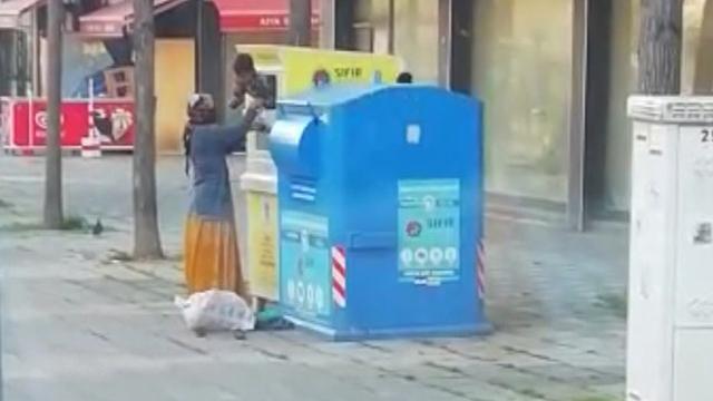 Giysi kumbarasına giren çocuk topladığı kıyafetleri annesine verdi