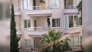 Polisi gören şüpheli balkondan balkona sarktı