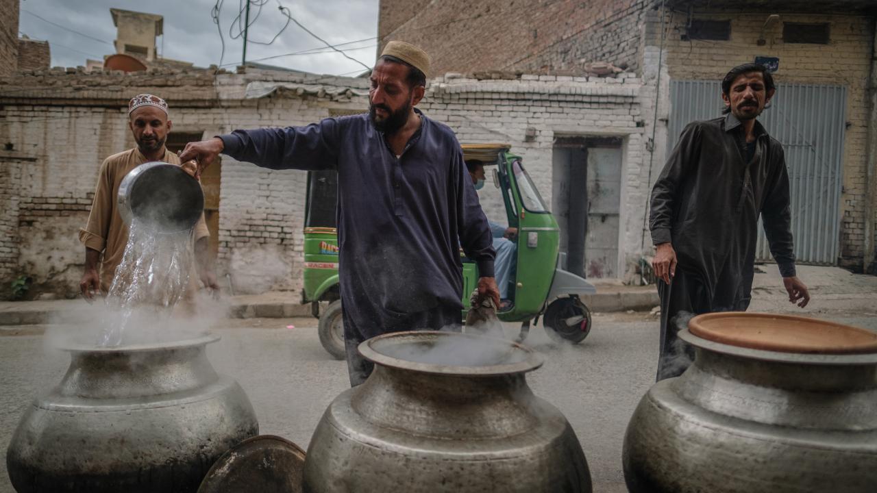 Sokakta yemek pişiren Pakistanlılar
