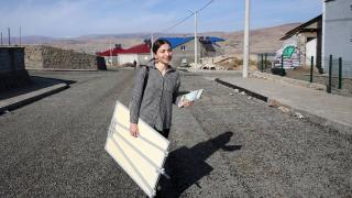 Elinde sınıf tahtasıyla kadınlar için kapı kapı geziyor