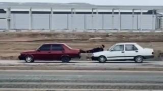 Kaputa yatıp ayaklarıyla öndeki aracı itti
