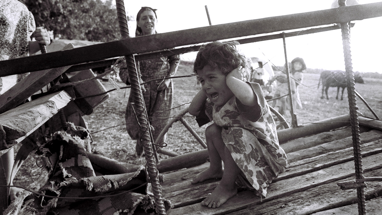 Fotoğrafta o dönemde katliamdan kaçıp Ağdam kırsalında yaşayan siviller ile ateş sesinden korkmuş bir çocuk görülüyor. (Arşiv)