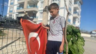 Küçük Emiralp çöpte gördüğü bayrakları temizleyip direğe astı