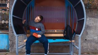 Kaldırımda oturarak servis bekleyen Eren'e özel durak