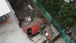 Bir bina yolda oluşan dev çukurun içine devrildi