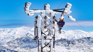 Kar ve buzla kaplanan elektrik direklerine tırmanarak kesintisiz enerji için çalışıyorlar