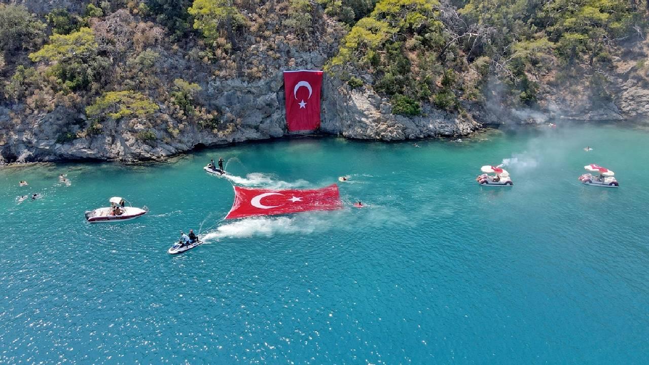 Muğla'da JAK timi Zafer Bayramı'nı deniz yüzeyi ve kayalıklarda açılan Türk bayrağıyla kutladı