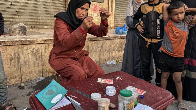 Filistinli kadın, eski ve yırtılmış banknotları onararak ailesinin geçimini sağlıyor
