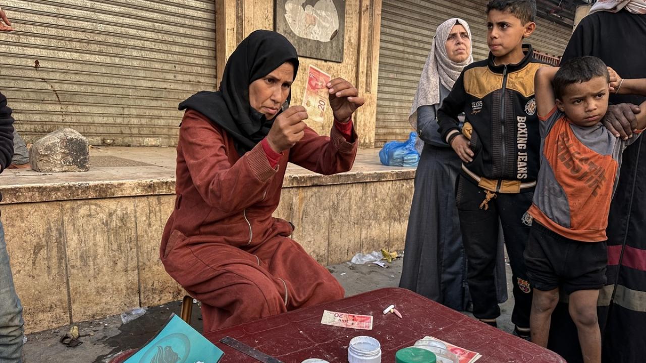 Filistinli kadın, eski ve yırtılmış banknotları onararak ailesinin geçimini sağlıyor