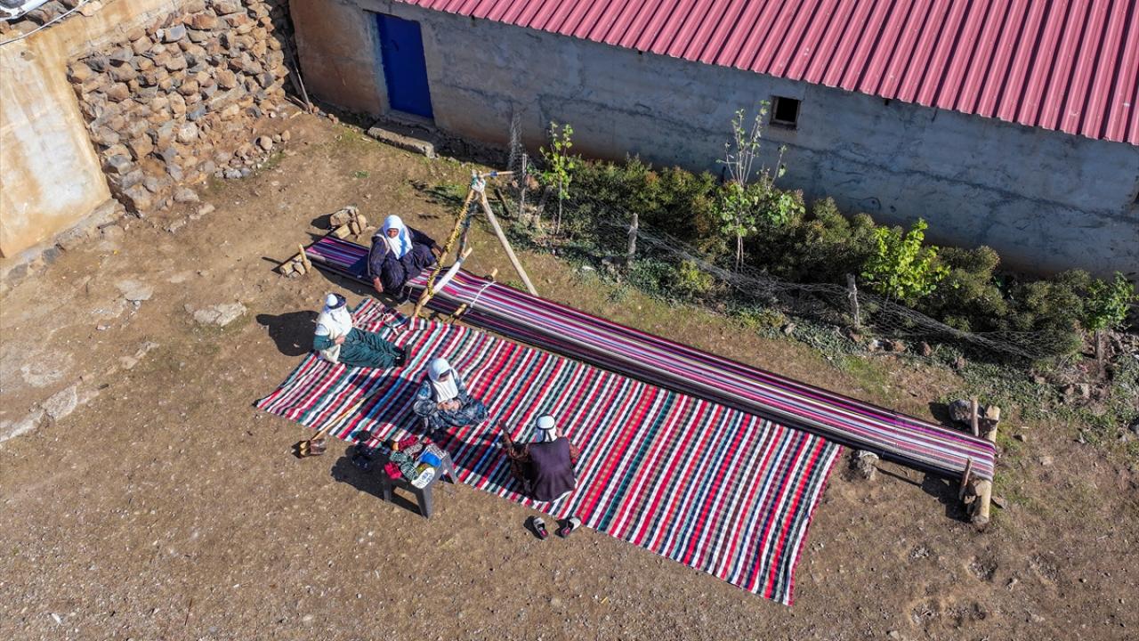 Evinin bahçesindeki tezgahta asırlık yöntemle kilim dokuyor