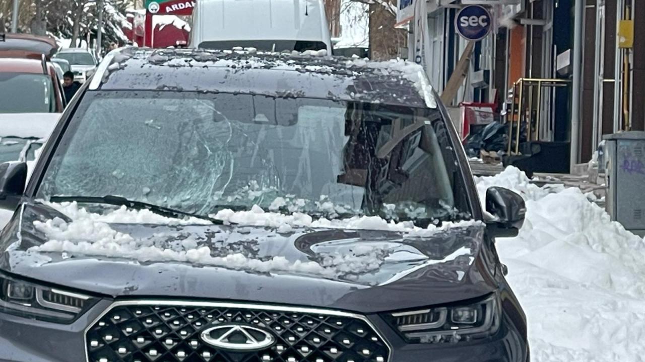 Park halindeki otomobilin üzerine kar ve buz kütlesi düştü