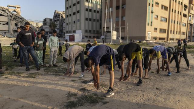 Gazze'de Filistinli gençler antrenmanlarını boş arazide yapıyor