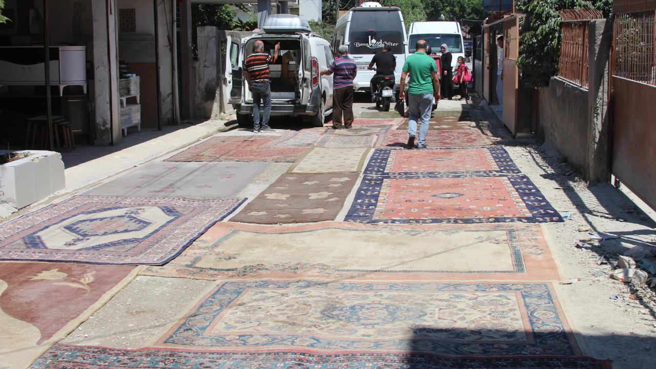 Asfaltlanmayan sokağın tozundan rahatsız olan mahalleli yola halı serdi