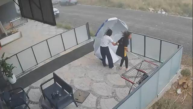 Şiddetli rüzgarın şemsiyeyle imtihanı kamerada