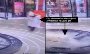 Yürürken cep telefonuyla uğraşan kadın havuza düştü