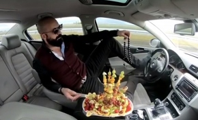 Ayağıyla direksiyonu kontrol edip meyve tabağıyla keyif yaptı