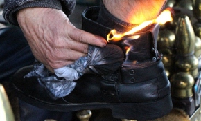 Müşterilerin ayakkabılarını ateşle yakarak boyuyor